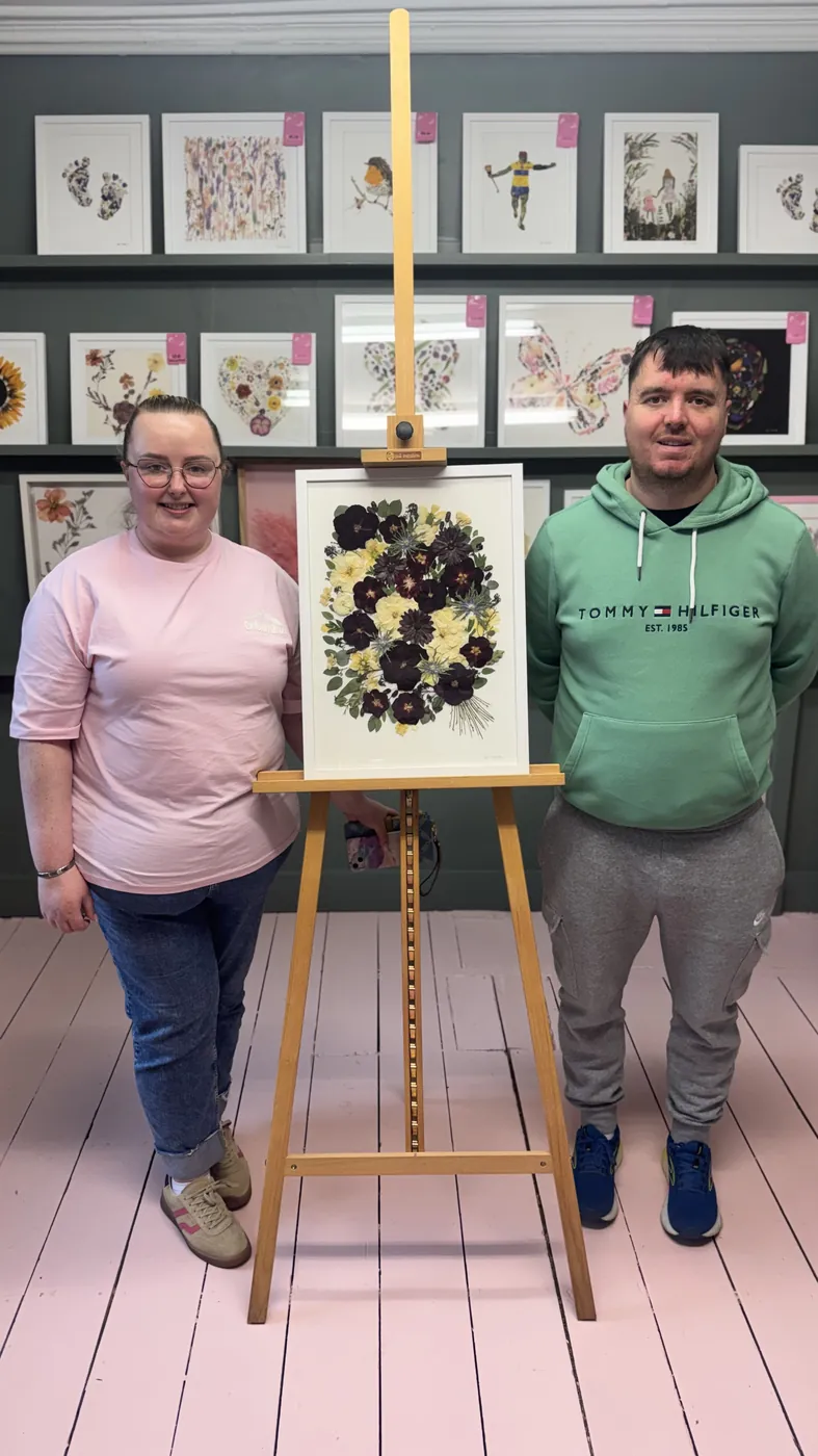 A happy bride with her framed pressed wedding bouquet