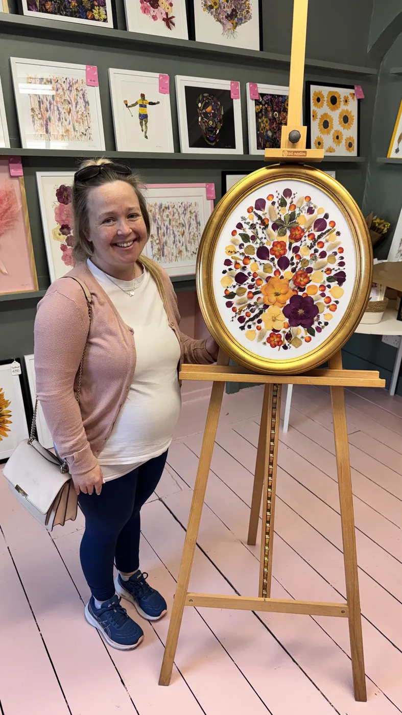 A happy bride with her framed pressed wedding bouquet
