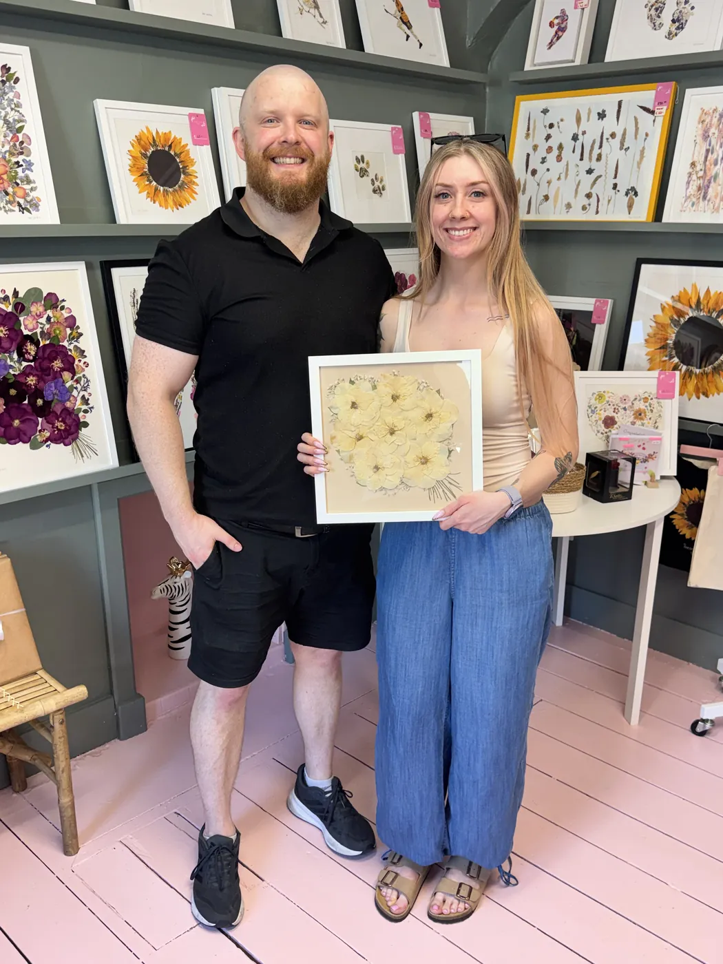 A happy bride with her framed pressed wedding bouquet