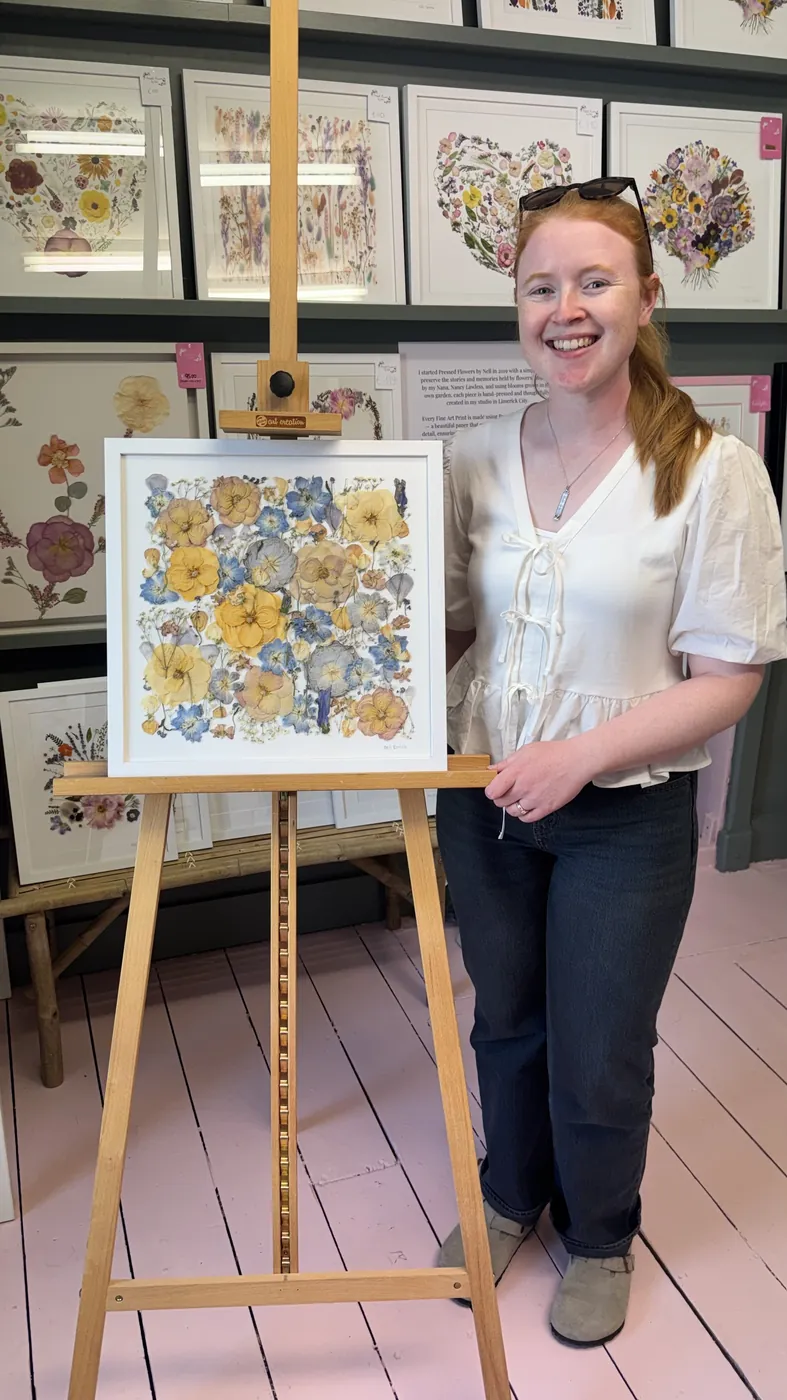 A happy bride with her framed pressed wedding bouquet