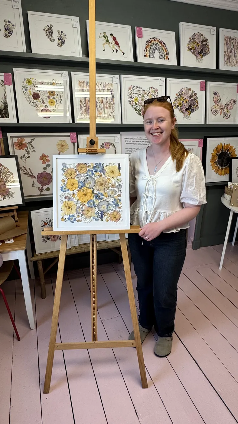 A happy bride with her framed pressed wedding bouquet