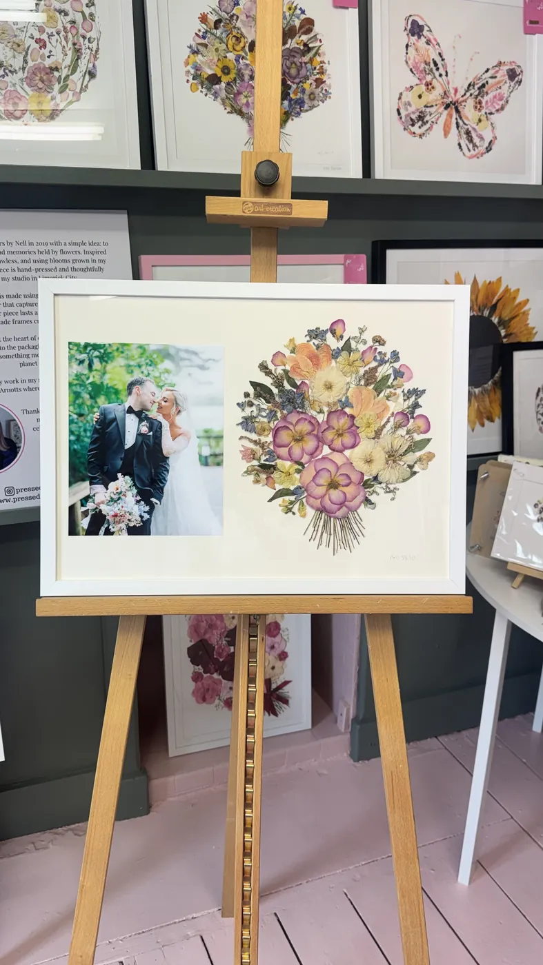 A happy bride with her framed pressed wedding bouquet