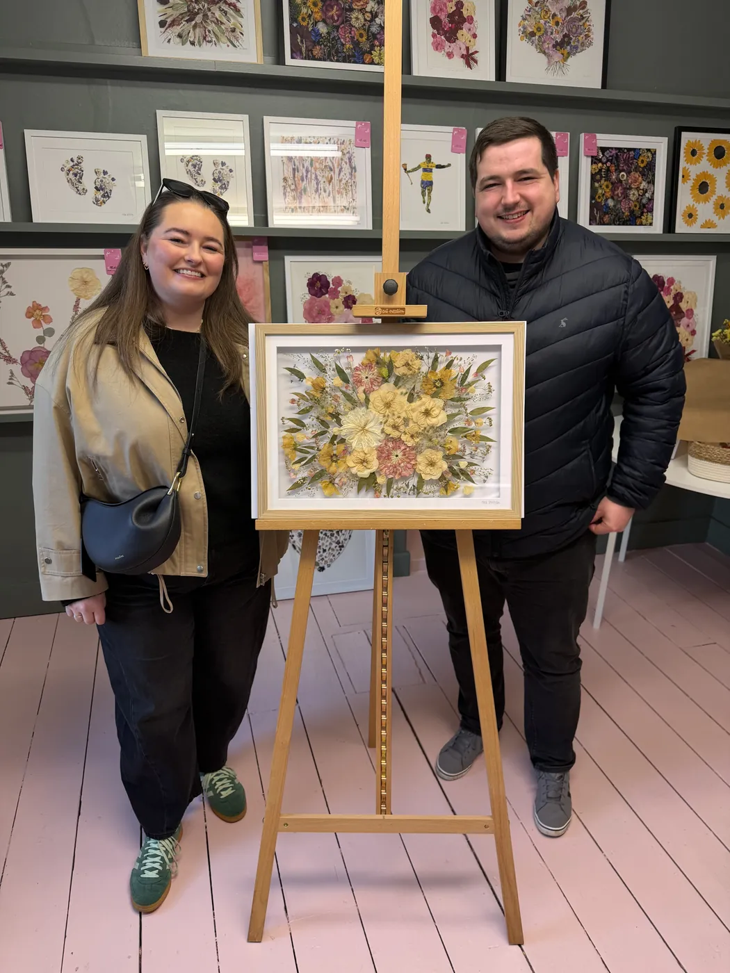A happy bride with her framed pressed wedding bouquet