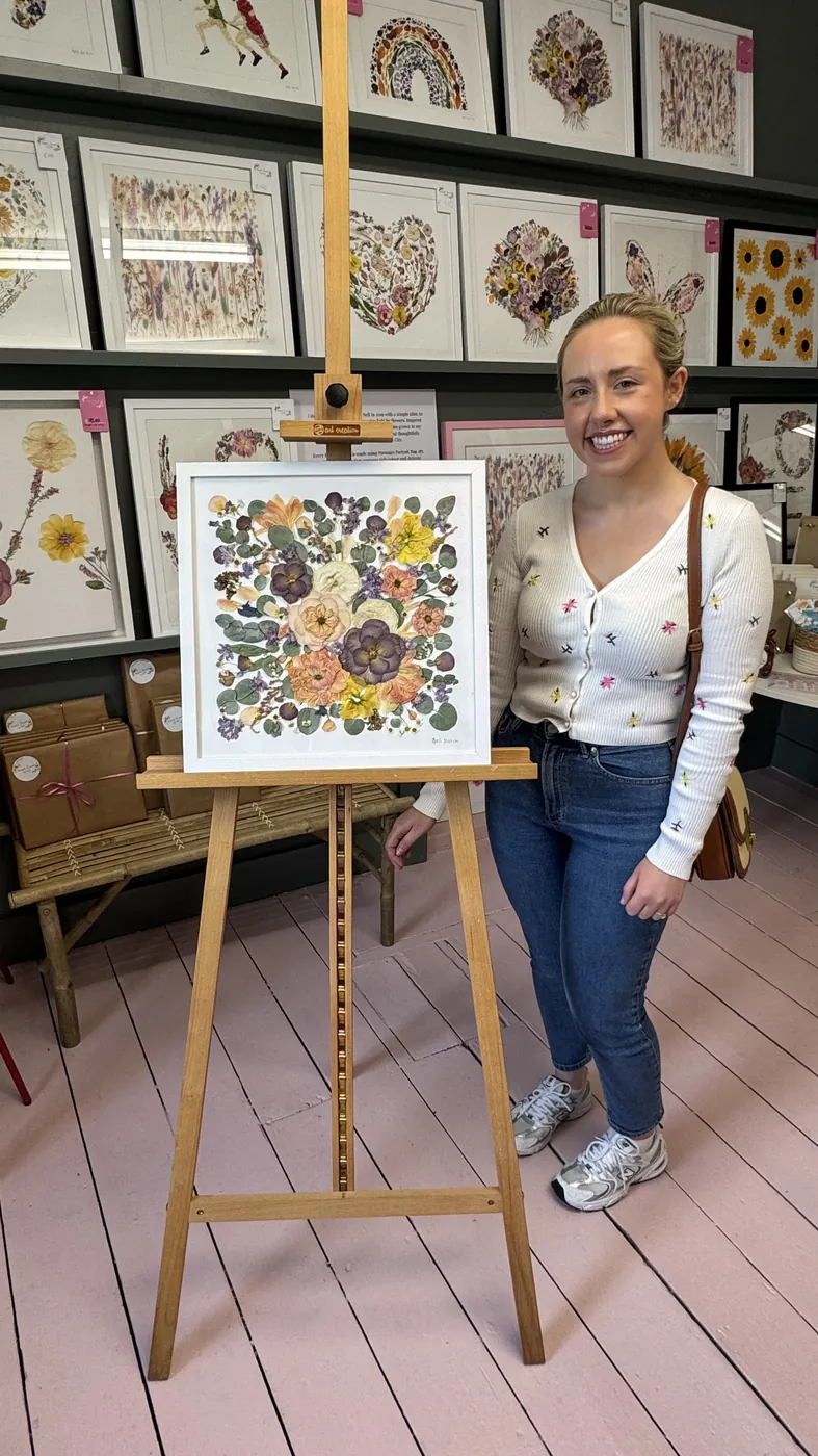 A happy bride with her framed pressed wedding bouquet