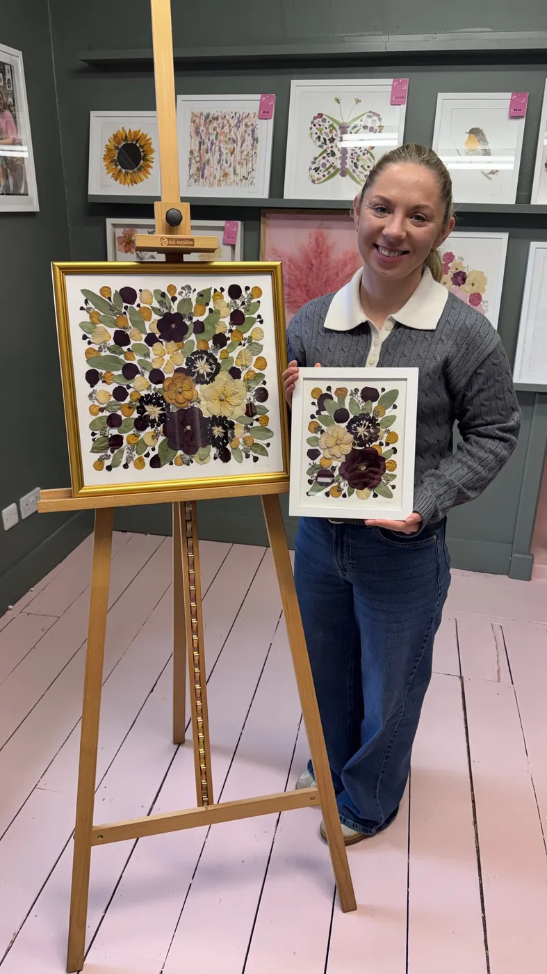 A happy bride with her framed pressed wedding bouquet