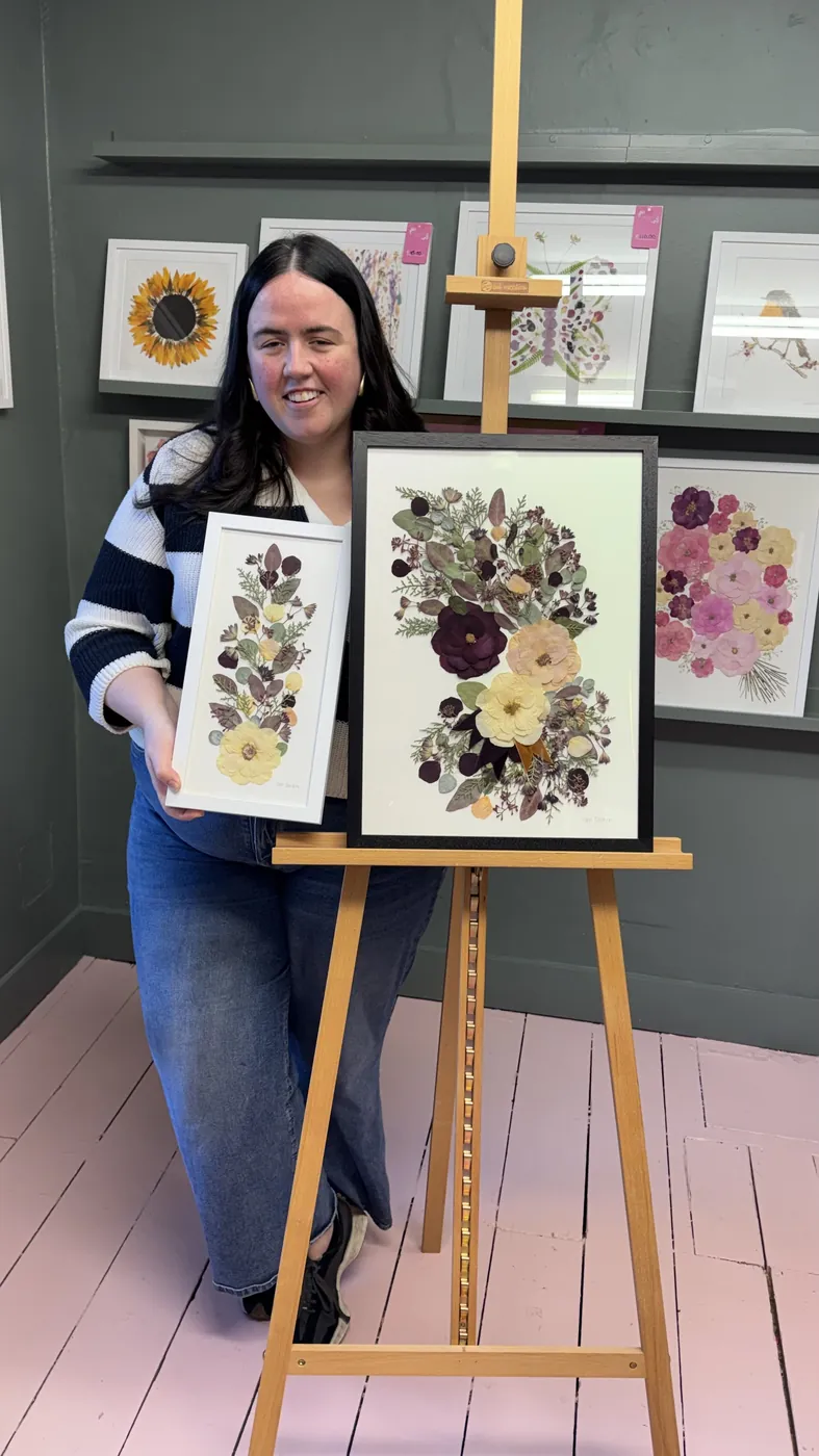 A happy bride with her framed pressed wedding bouquet