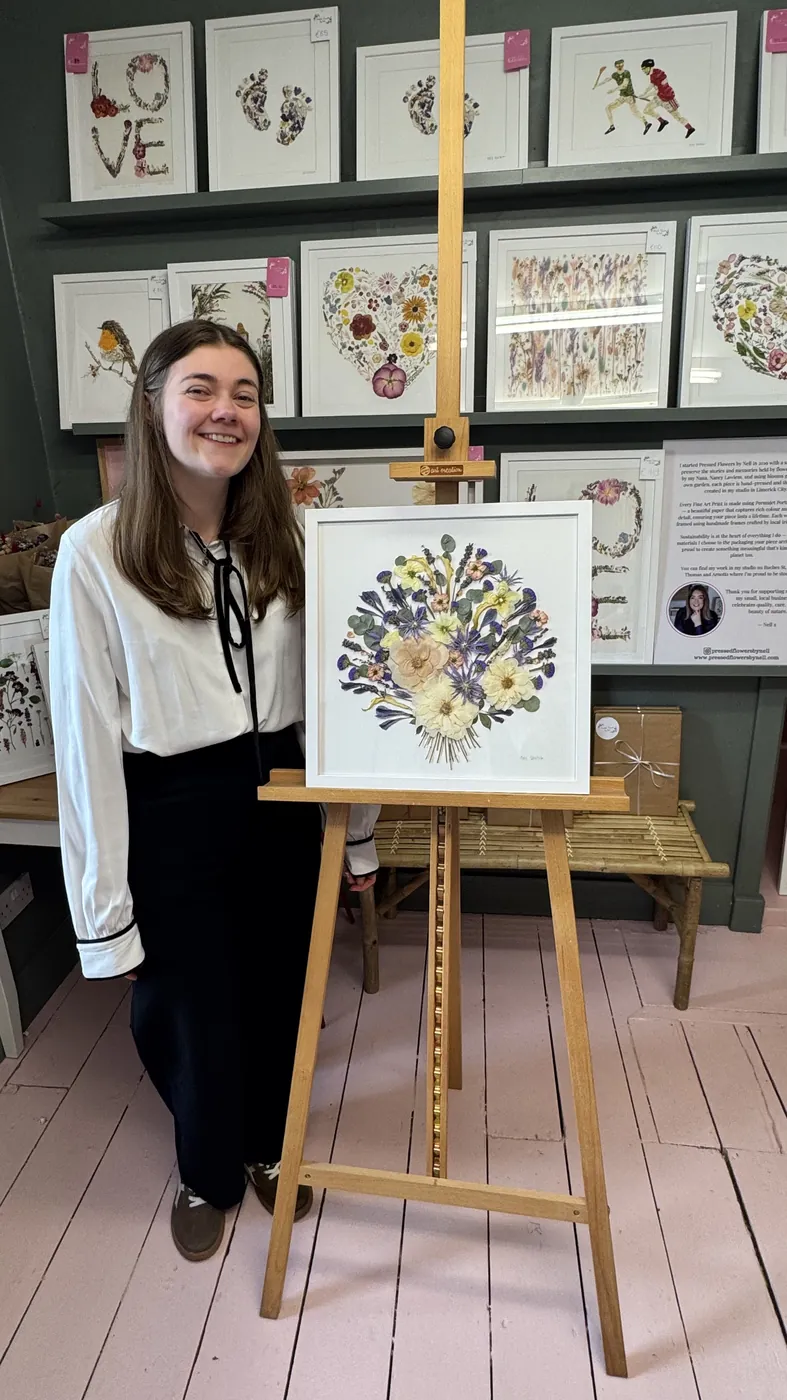 A happy bride with her framed pressed wedding bouquet