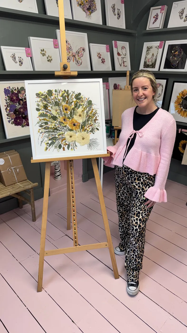 A happy bride with her framed pressed wedding bouquet