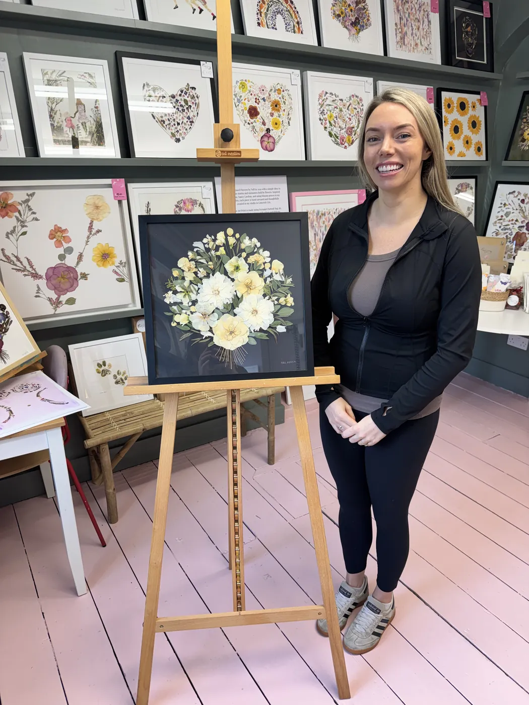 A happy bride with her framed pressed wedding bouquet