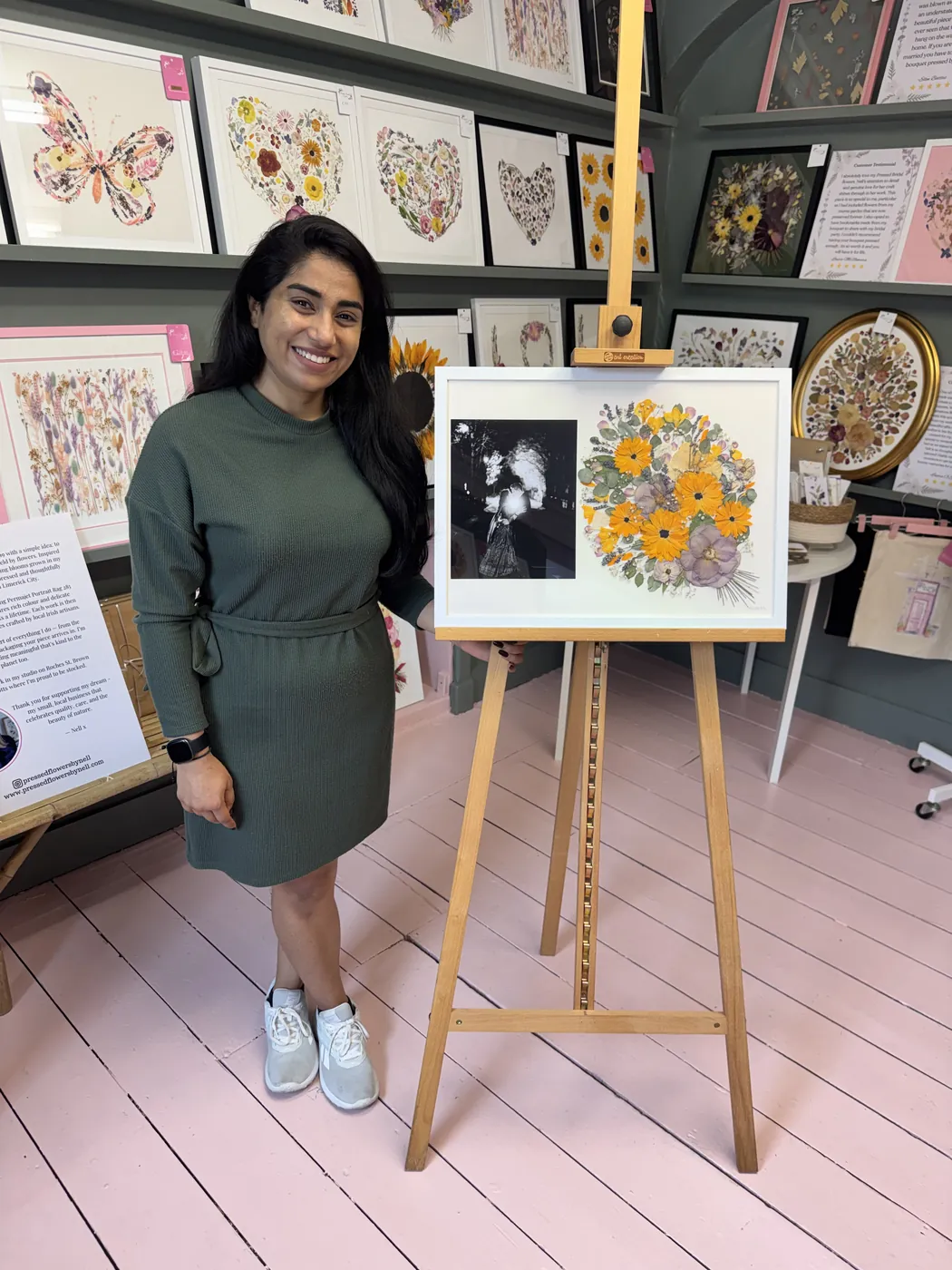 A happy bride with her framed pressed wedding bouquet