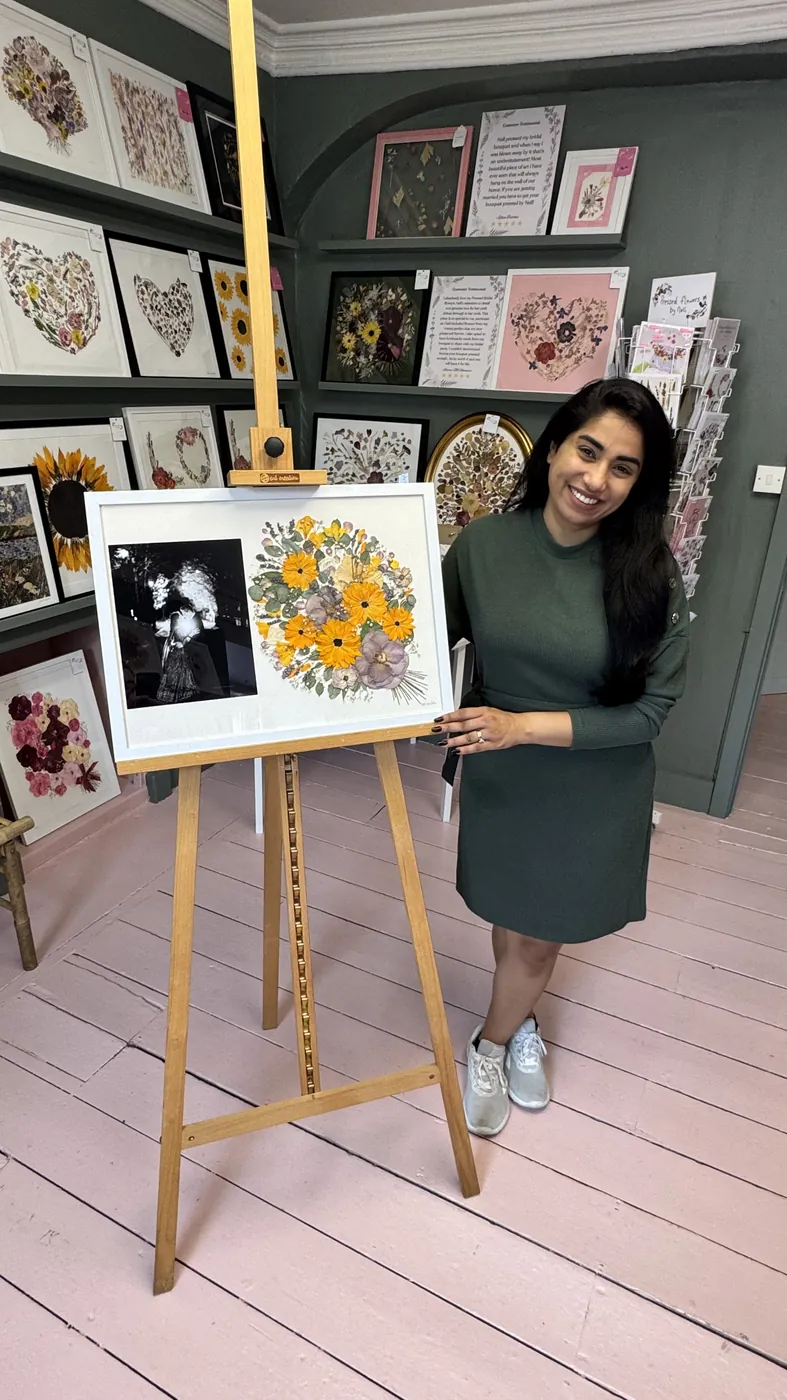 A happy bride with her framed pressed wedding bouquet