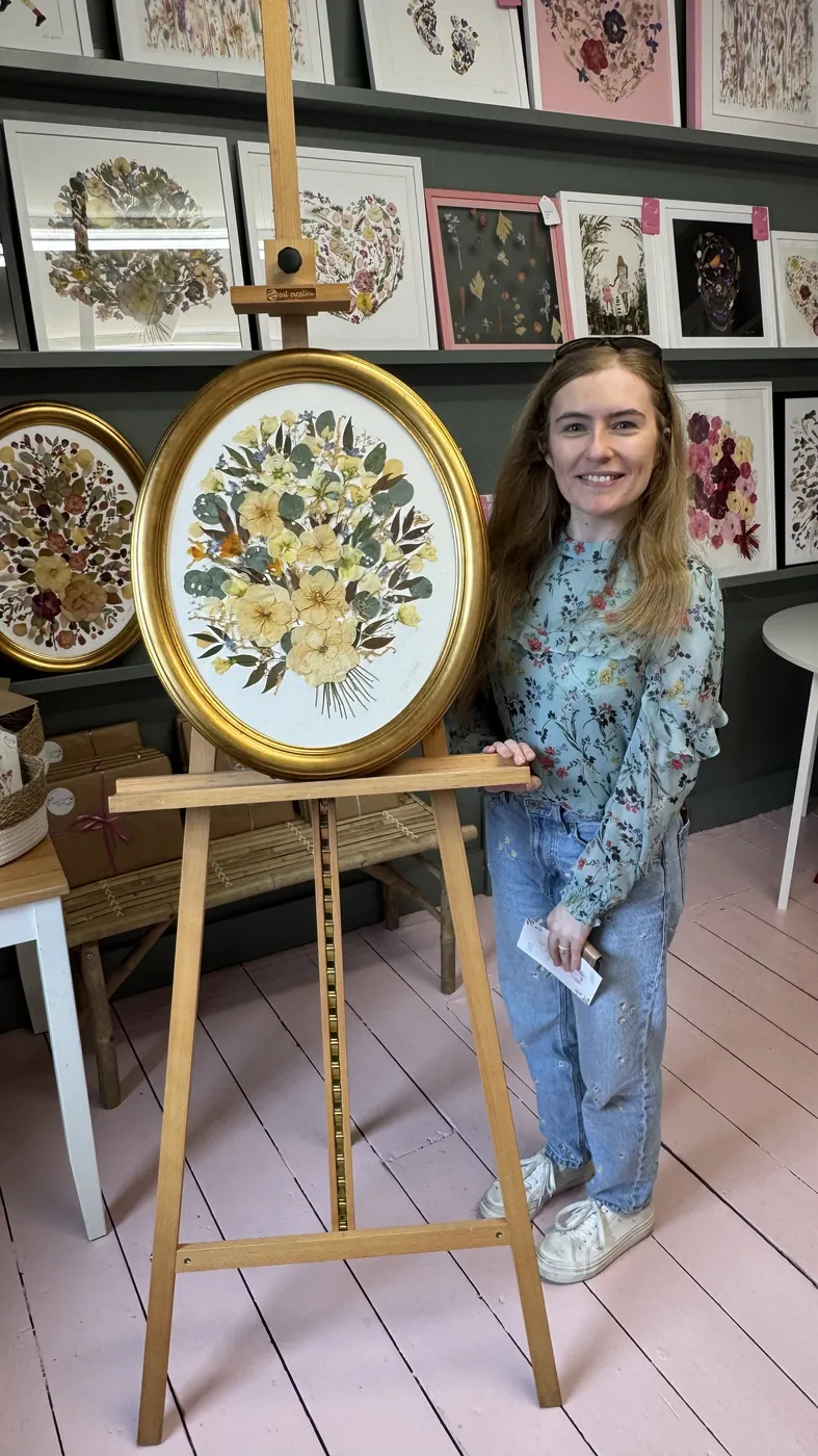 A happy bride with her framed pressed wedding bouquet