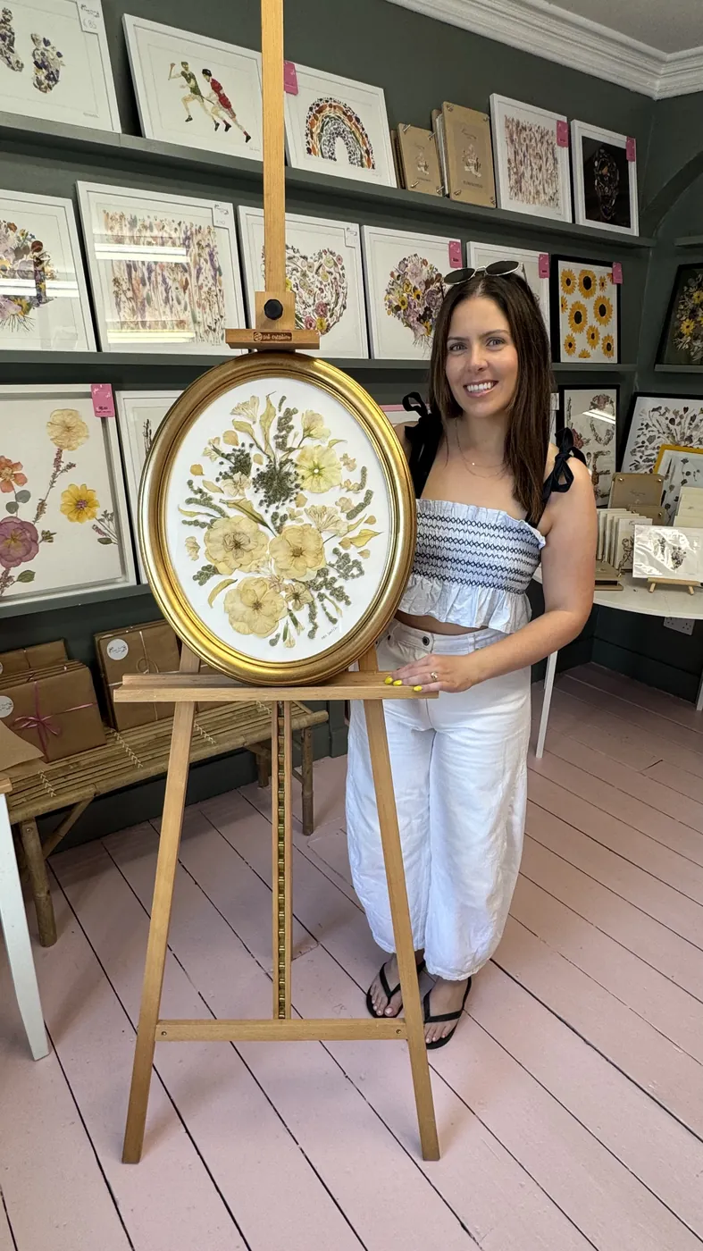 A happy bride with her framed pressed wedding bouquet