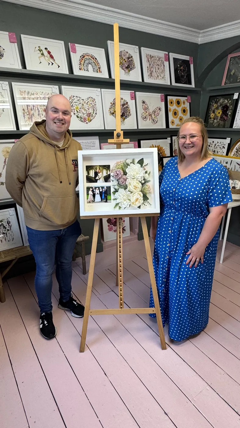 A happy bride with her framed pressed wedding bouquet