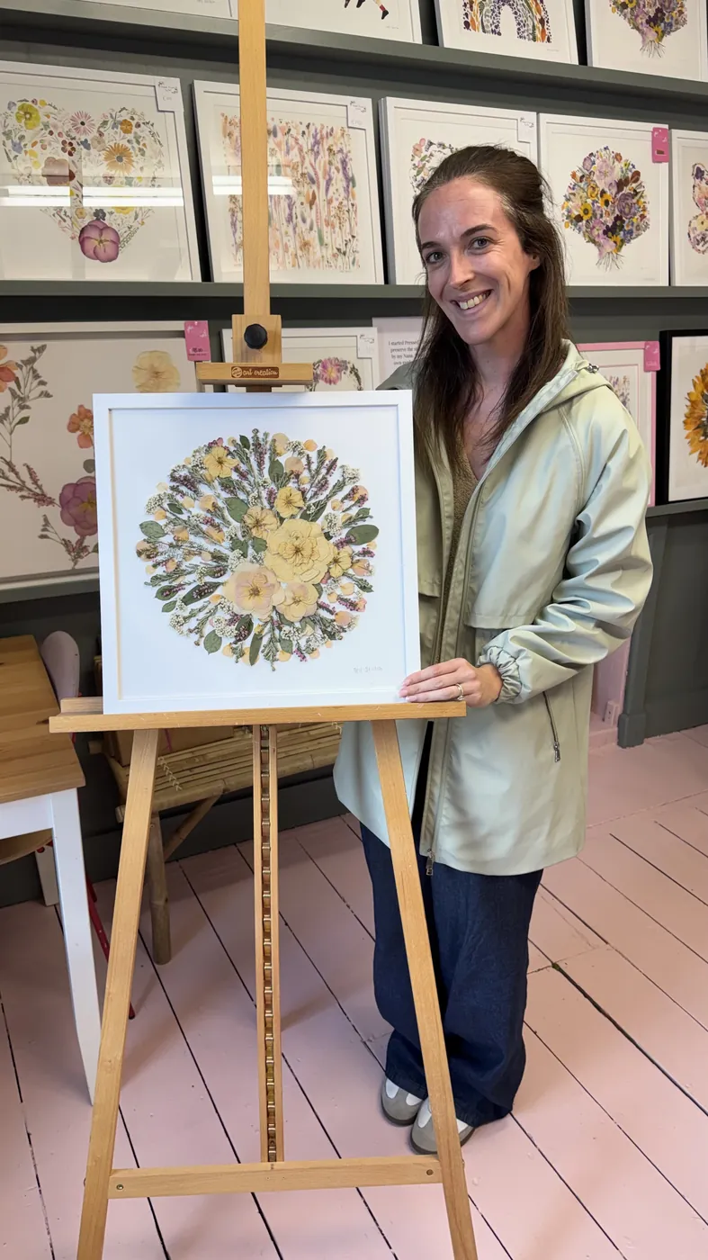 A happy bride with her framed pressed wedding bouquet