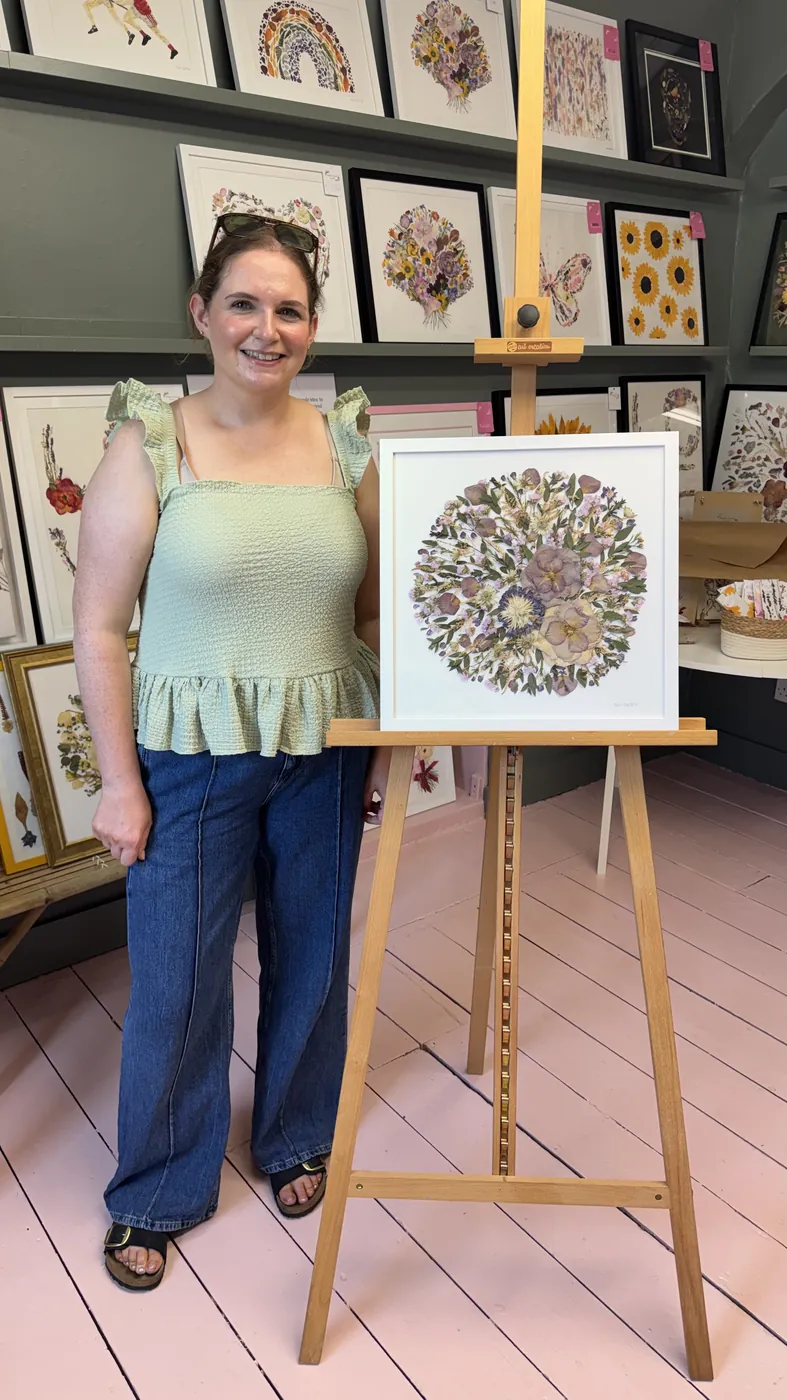 A happy bride with her framed pressed wedding bouquet