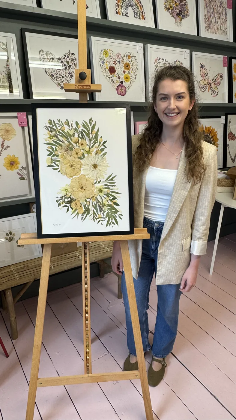 A happy bride with her framed pressed wedding bouquet
