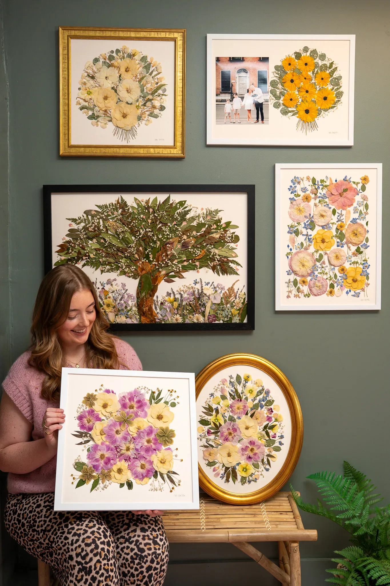 Nell holding a finished pressed bouquet beside a gold oval frame