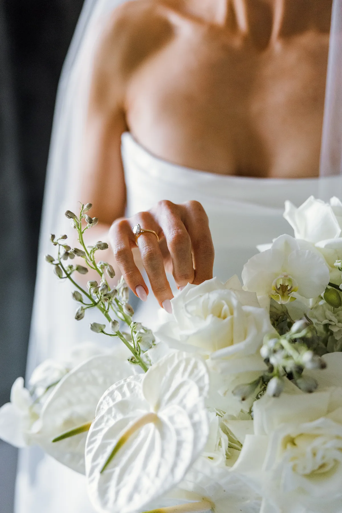 A bride holding white roses and anthurium