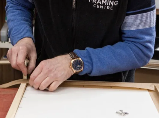 A framer fitting a wooden frame by hand